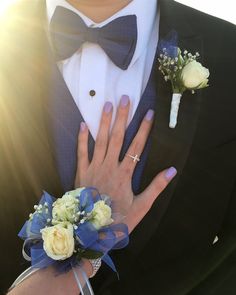 a close up of a person wearing a suit and tie with flowers in his lapel