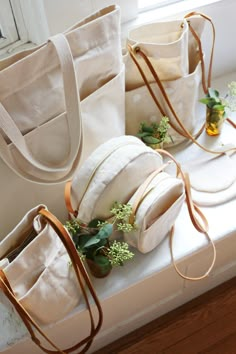 three white bags sitting on top of a window sill