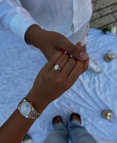 a woman holding the hand of a man with a diamond ring on his left wrist