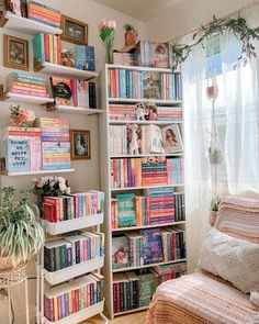 a room filled with lots of books on top of a book shelf next to a window