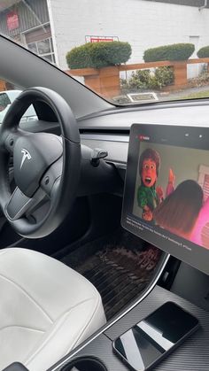 the inside of a car with an electronic device in it's center console and steering wheel