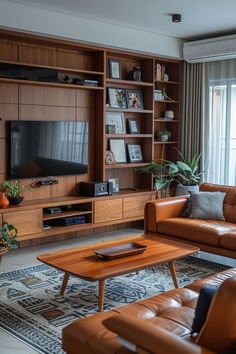 a living room filled with furniture and a flat screen tv mounted on a wooden entertainment center