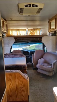 the inside of a camper with two chairs and a couch in front of it