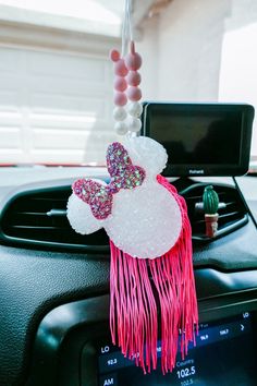 a car dashboard with an air freshener hanging from it's holder and beads