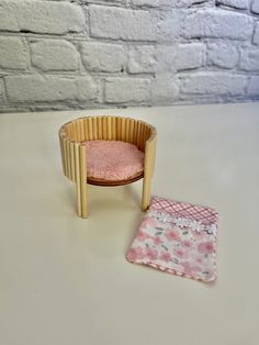 a small wooden chair with a pink cushion next to it