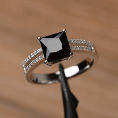 a black diamond ring sitting on top of a wooden table