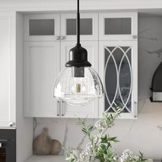 a kitchen with white cabinets and a black light hanging from the ceiling over the counter