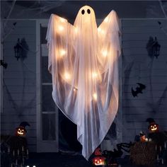 a lighted ghost hanging from the side of a house