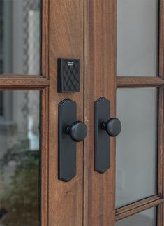 a close up of a wooden door with black handles