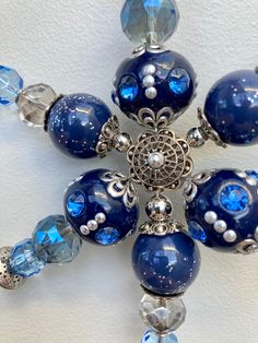 a blue and white beaded brooch with glass beads on it's side