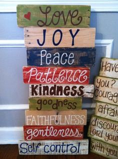 a stack of wooden blocks with words painted on them and the word love joy in different languages