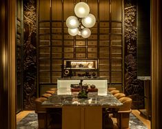 an elegant dining room with marble counter tops and wooden paneling, along with leather chairs