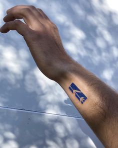 a person's arm with a blue and white sticker on it that says k