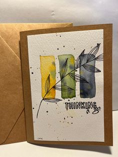 a card with watercolor leaves and the words thinking on it