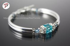 ------------- Swarovski turquoise cube crystal hugged by Swarovski squaredelles  Double silver-plated curved tubes Antiqued silver plated bead spacers Silver plated toggle clasps, rings, wire protectors Beading Wire Length is about 7.25 inches but can be customized.  With matching earrings sold separately @ https://www.etsy.com/listing/214260552/light-blue-crystal-earrings-turquoise?ref=shop_home_active_15 Thank you for visiting my shop!Comes in elegant jewelry box ready for gift-giving! Elegant Blue Stackable Crystal Bracelet, Silver Cube Jewelry For Gifts, Elegant Turquoise Birthstone Bracelets, Adjustable Blue Crystal Bracelet For Anniversary, Hypoallergenic Turquoise Jewelry For Anniversary, Turquoise Crystal Bangle Bracelet As Gift, Turquoise Bangle Crystal Bracelet For Gift, Turquoise Bangle Crystal Bracelet As Gift, Turquoise Sterling Silver Bracelets For Anniversary