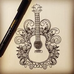 a drawing of an acoustic guitar with floral designs on it and a pen next to it