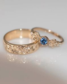 two gold wedding rings with blue sapphire stones