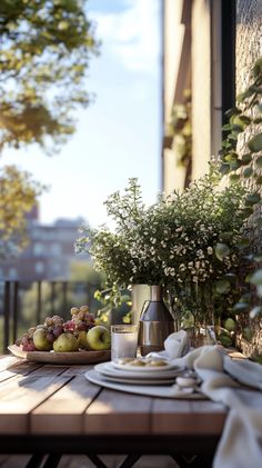 an outdoor table with plates, cups and vases filled with flowers on top of it