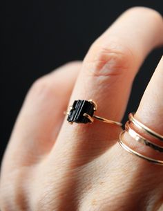 A stunning piece of Raw Black Tourmaline is showcased in a custom built, 14K Gold Fill prong setting. This piece - while delicate in design - makes a bold statement through the contrast of the bright metal against the deep black of the tourmaline stone. Black Stone Rings, Black Tourmaline Wedding Ring, Black Tourmaline Aesthetic, Black Tourmaline Jewelry, Black Tourmaline Ring, Black Tourmaline Stone, Jewelry Product Shots, Raw Black Tourmaline, Black Stone Ring