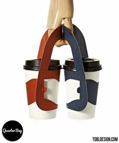 two coffee cups with wooden handles are stacked on top of each other in front of a white background