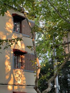 an apartment building with the sun shining on it's windows and shutters open