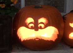 two pumpkins with faces carved to look like they have eyes and beards on them