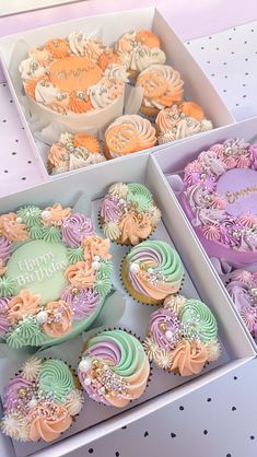 two boxes filled with colorful cupcakes on top of a table