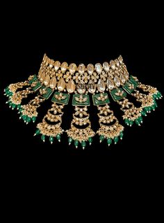 Tiana I - Indian Bridal Set w/ Emerald Drops, Kundan & Green Meenakari work Stunning modern choker necklace for Indian brides with Kundan stone setting. Fit for any fashionista who appreciates the beauty of fine craftsmanship and design all in one stunning set! Stunning green Meenakari work adorns this bridal set in square-shaped metal detail. This set is elaborated with moon design detailing of Kundan gems. This classic bridal jewelry is further accented with mini green emerald stone drops at t Opulent Bridal Necklace With Intricate Design For Festive Occasion, Elegant Kundan Choker Necklace With Tilla, Kundan Choker With Intricate Design, Ceremonial Kundan Choker With Intricate Design, Bridal Temple Jewelry Cutdana Choker, Opulent Wedding Necklace With Intricate Design, Kundan Bridal Choker With Intricate Design, Kundan Cutdana Choker For Ceremonial Occasions, Ceremonial Heavy Kundan Choker Necklace