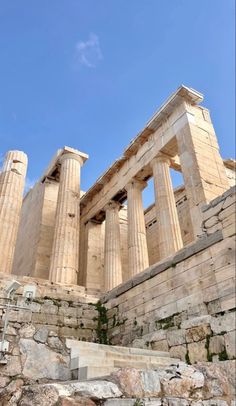 an ancient building with three columns and steps