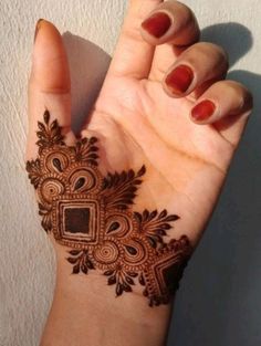 a woman's hand with a henna tattoo on it