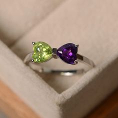 This ring features two 6*6mm heart cut genuine amethyst and peridot and sterling silver finished with rhodium. Customization is available. It is made by hand, and it will take about 7 days to finish the ring after your payment is completed. Main stone: natural amethyst, natural peridot Green Heart-cut Birthstone Ring As Gift, Green Birthstone Heart Ring For Promise, Green Heart Cut Birthstone Ring For Gift, Green Heart Cut Birthstone Ring As Gift, Green Heart Birthstone Ring For Promise, Green Heart Birthstone Promise Ring, Peridot Birthstone Ring In White Gold, Sterling Silver Heart Cut Amethyst Promise Ring, Green Amethyst Ring For Anniversary, May Birthstone