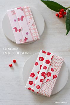 two pieces of paper sitting on top of a white plate next to berries and leaves