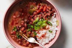 a pink bowl filled with beans and rice