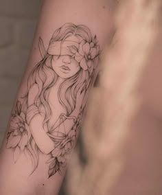 a woman's arm with a flower and leaves tattoo on the left side of her arm