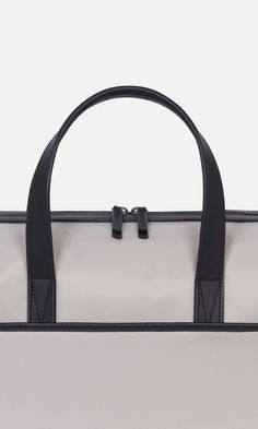 Designed to be the perfect piece of hand luggage, our overnight bag will sit neatly under the seat in front of you on a plane, and has a back sleeve to slot over a suitcase handle. It doubles up as an ideal gym bag and comes with a detachable shoulder strap (you'll find this inside a pocket on arrival). Inside, there are plenty of slip pockets including one for a laptop. This holdall is finished with premium leather details. Durable nylon Water-resistant Fits a laptop up to 13” Dimensions 16.34 Modern Travel Bag With Handles For On-the-go, Rectangular Nylon Briefcase With Luggage Sleeve, Travel Weekender Tote With Adjustable Handle, Travel Weekender Bag With Adjustable Handle, Adjustable Handle Tote Weekender Bag For Travel, Weekender Tote Bag With Adjustable Handle For Travel, Modern Top Handle Travel Bag, On-the-go Travel Bag Satchel With Adjustable Handle, Travel Briefcase With Luggage Sleeve In Nylon