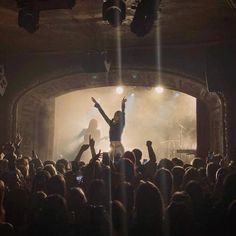 a group of people standing on top of a stage with their arms in the air