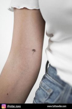 a small palm tree tattoo on the arm