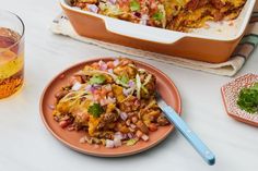 a plate of mexican food next to a glass of water and a dish on the table