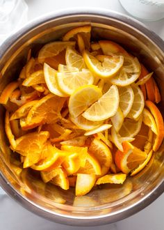 a pot filled with sliced oranges and lemons on top of a white table