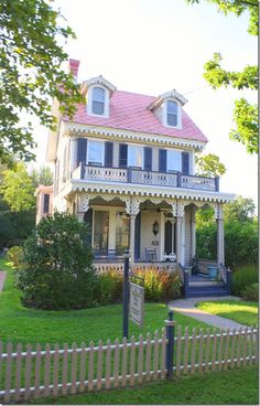 a house with a pink roof and white picket fence