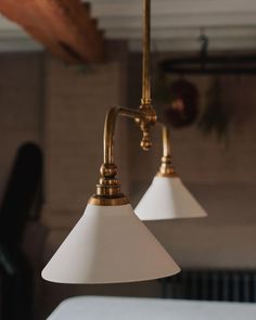 two white lamps hanging from the ceiling in a room