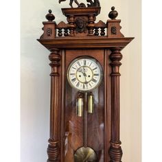 an old wooden clock with roman numerals and a horse on the front side