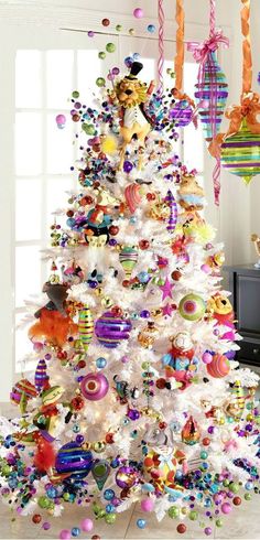 a white christmas tree decorated with colorful ornaments