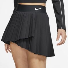 a woman wearing a black skirt with white nike logo on it