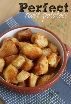 a brown bowl filled with fried potatoes on top of a blue and white table cloth