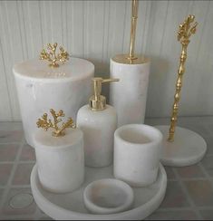 white bathroom accessories set with gold accents on the top and bottom, including soap dispenser