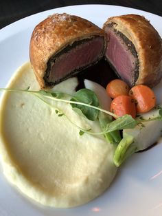 a white plate topped with meat and vegetables