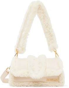 Padded shearling shoulder bag in beige. Logo hardware at face. · Detachable carry handle · Detachable shoulder strap · Patch pocket at back face · Foldover flap · Patch pocket at interior · Cotton twill lining · Logo-engraved gold-tone hardware · H4.5 x W8 x D4 in Part of the Le Chouchou collection. Supplier color: Light beige Jacquemus Bags, Jacquemus Bag, Luxurious Bags, Dr Closet, Pretty Bags, Leather Messenger Bag, Cute Bags, Leather Messenger, Light Beige