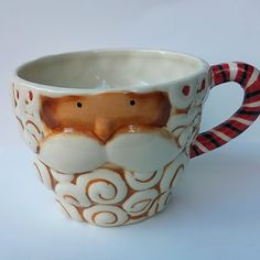 a coffee cup with a santa clause design on the inside and sides, sitting on a white surface