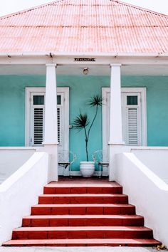 a blue house with red steps leading up to it